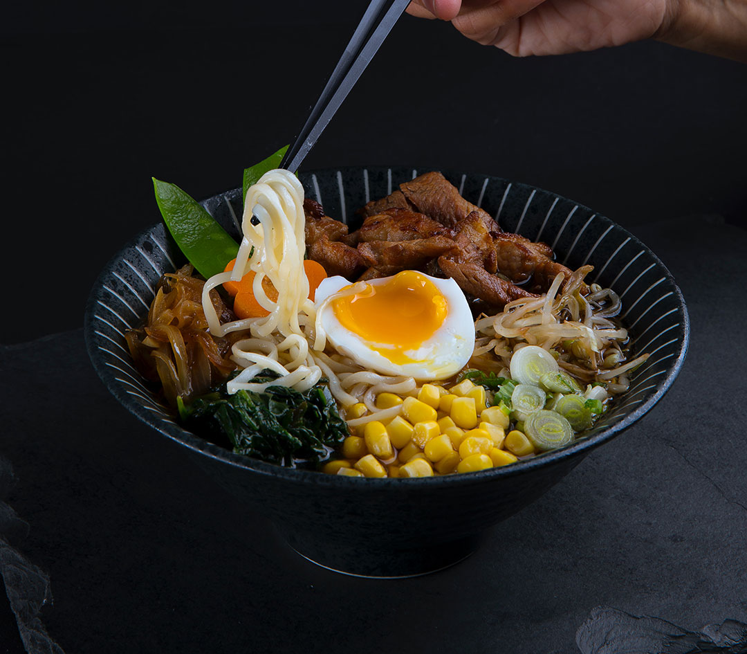 ramen in a black bowl