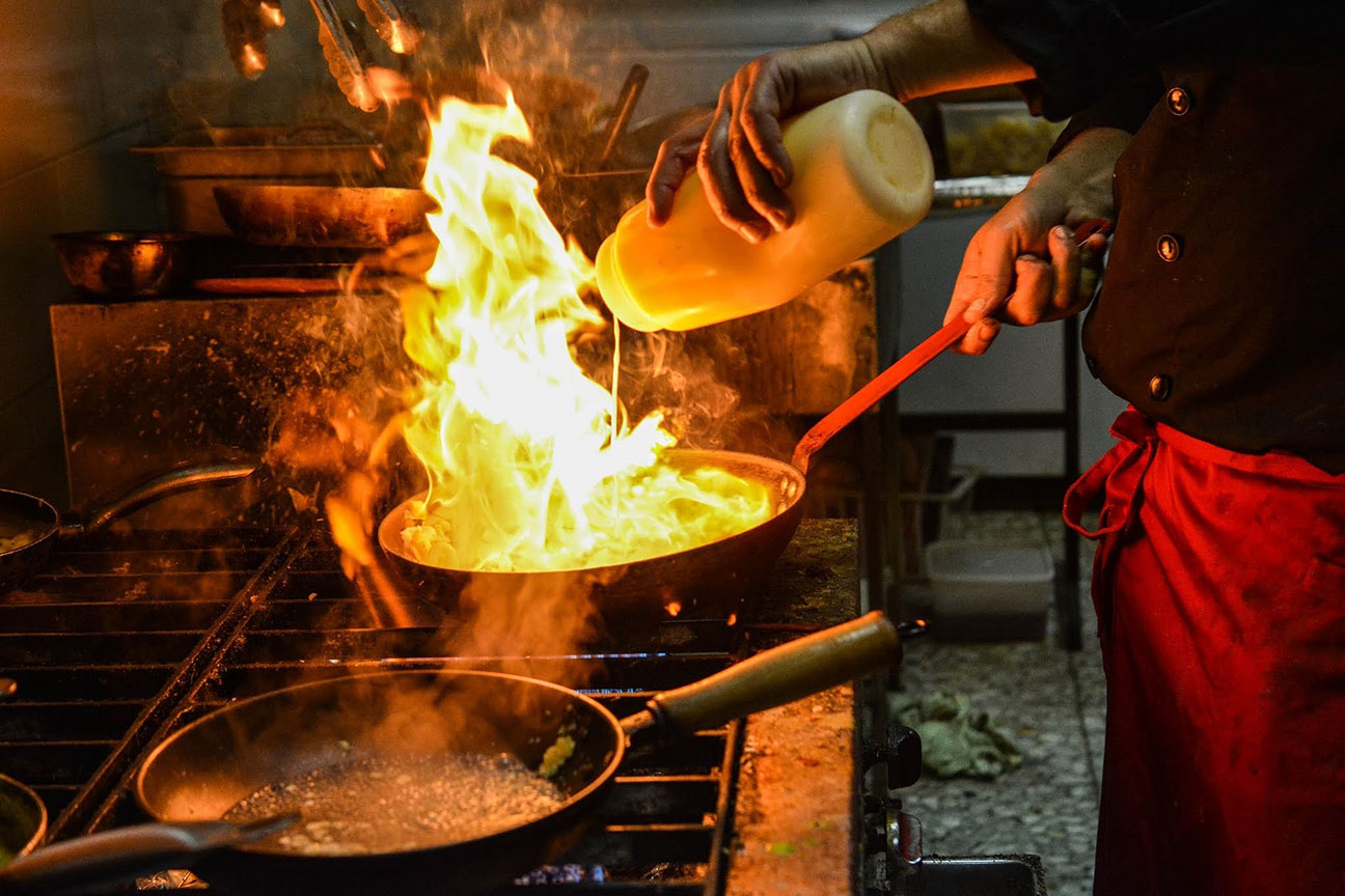 man cooking flambe