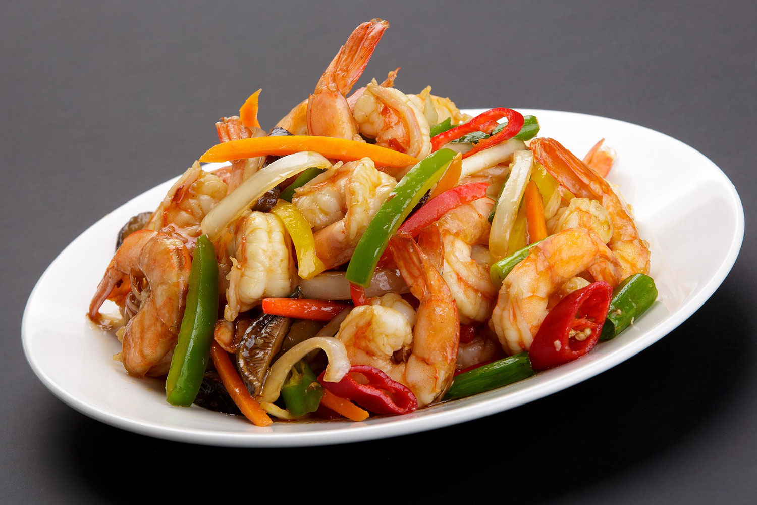 shrimp mixed with vegetables on a white plate