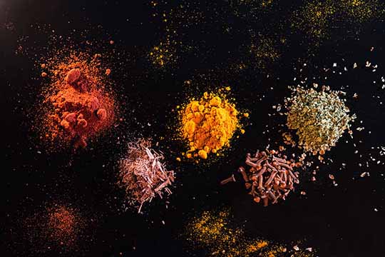 piles of spices on a black background